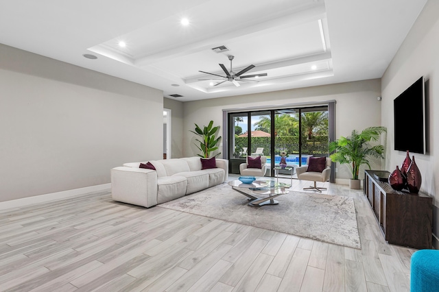 living area featuring a ceiling fan, recessed lighting, visible vents, a raised ceiling, and light wood-type flooring