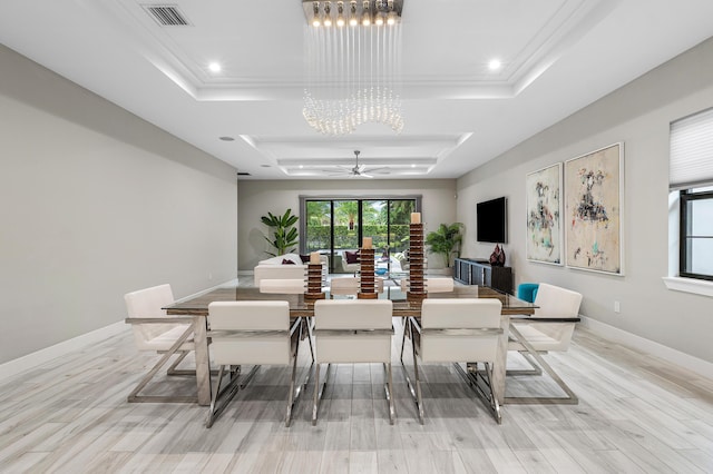 dining room featuring ceiling fan with notable chandelier, a tray ceiling, light wood-type flooring, visible vents, and recessed lighting
