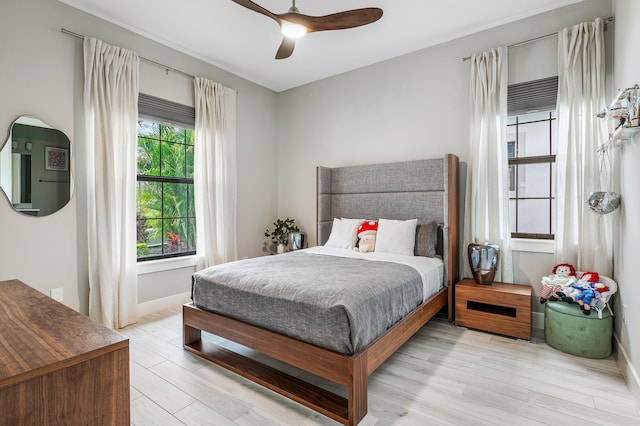 bedroom featuring baseboards, a ceiling fan, and light wood-style flooring