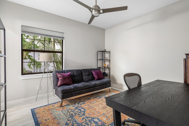 office space featuring baseboards, light wood-style flooring, and ceiling fan