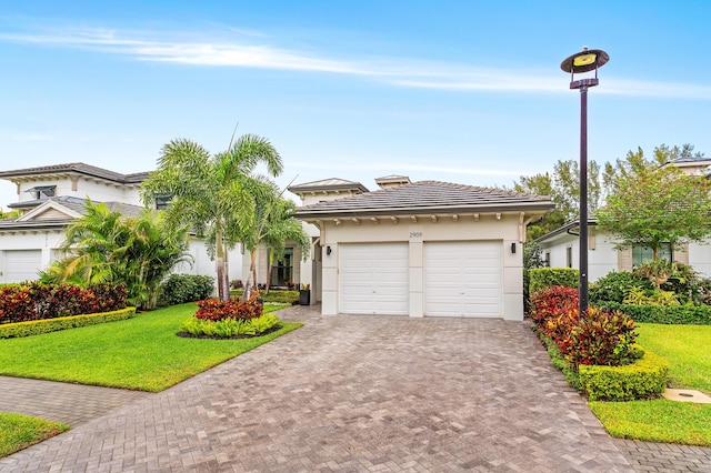 view of front of house featuring stucco siding, a garage, a front lawn, and decorative driveway