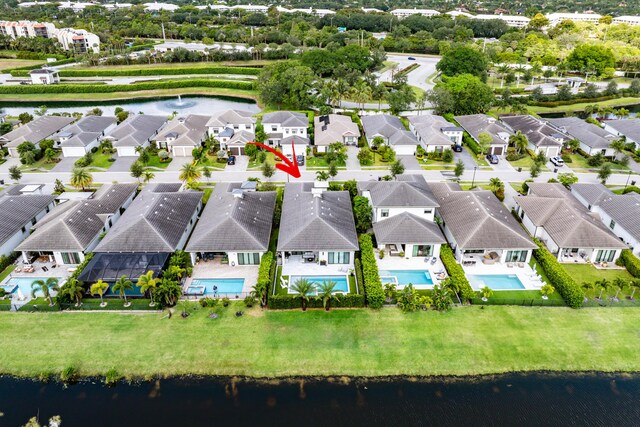 aerial view of residential area featuring a nearby body of water and a pool area