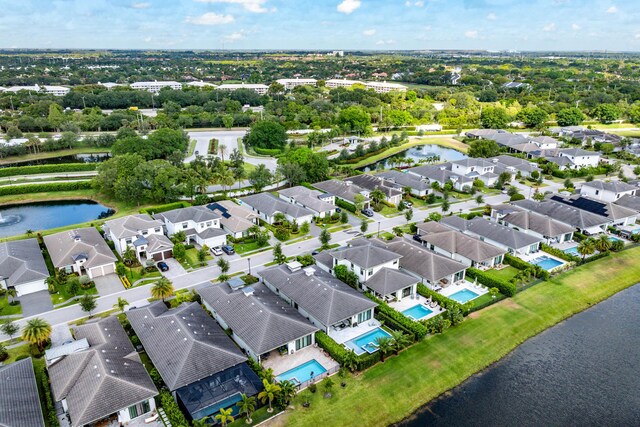 aerial perspective of suburban area featuring a nearby body of water and a pool area