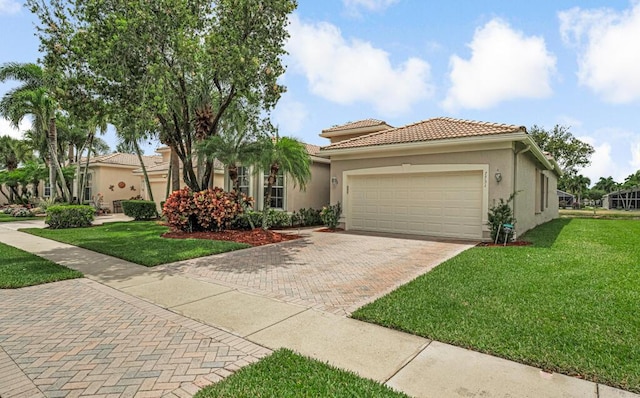 mediterranean / spanish-style house featuring a garage, a tiled roof, stucco siding, a front lawn, and decorative driveway