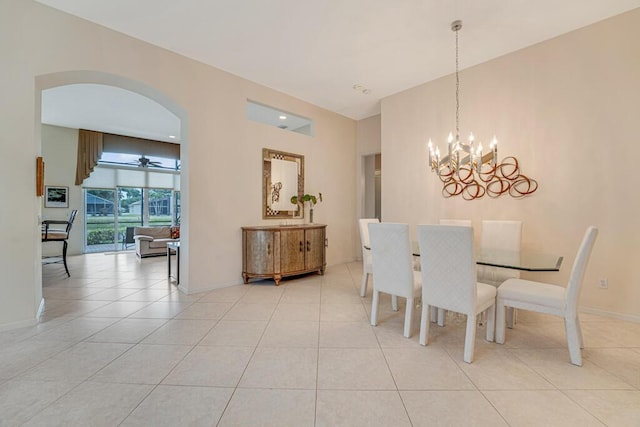 dining space with arched walkways, a notable chandelier, light tile patterned flooring, and baseboards