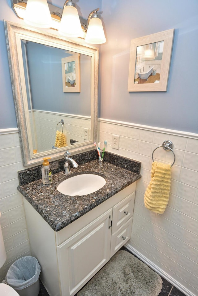 bathroom featuring tile walls, vanity, and wainscoting