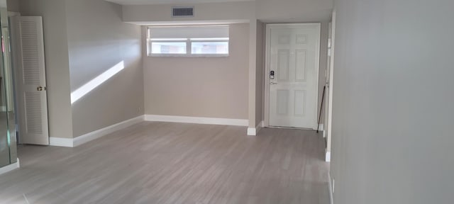 spare room with baseboards, visible vents, and wood finished floors
