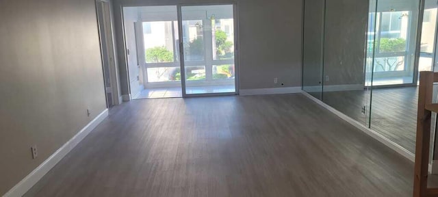 unfurnished room with baseboards and wood finished floors