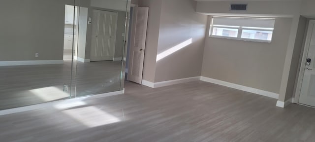 unfurnished bedroom featuring baseboards, visible vents, and wood finished floors