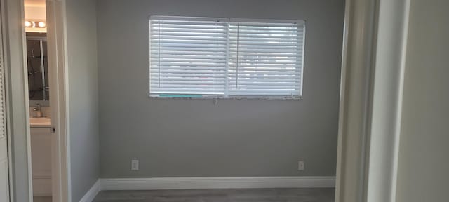 spare room featuring baseboards, a sink, and plenty of natural light