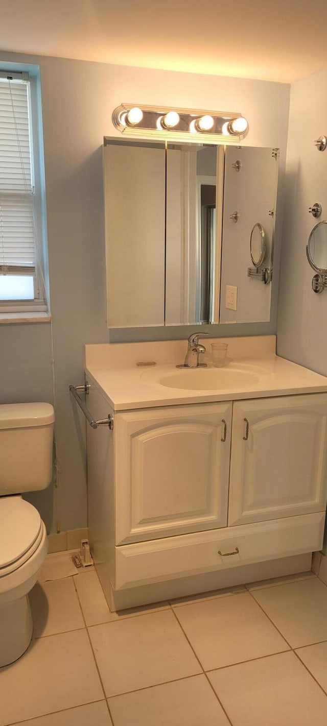 half bath with tile patterned flooring, toilet, and vanity