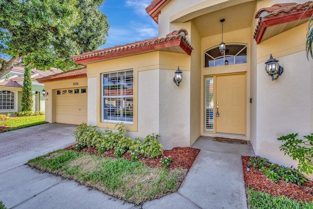 7026 Galleon Cv, Riviera Beach, FL 33418 - property entrance with stucco siding, an attached garage, and driveway