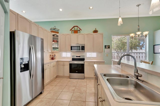 kitchen featuring a sink, pendant lighting, light countertops, light tile patterned floors, and appliances with stainless steel finishes