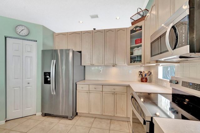 kitchen featuring light tile patterned flooring, decorative backsplash, visible vents, and appliances with stainless steel finishes