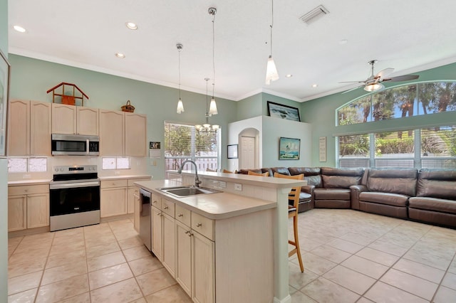 kitchen with appliances with stainless steel finishes, plenty of natural light, light tile patterned flooring, and a sink