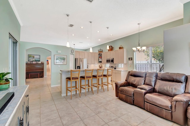 living area featuring ornamental molding, visible vents, an inviting chandelier, arched walkways, and light tile patterned floors