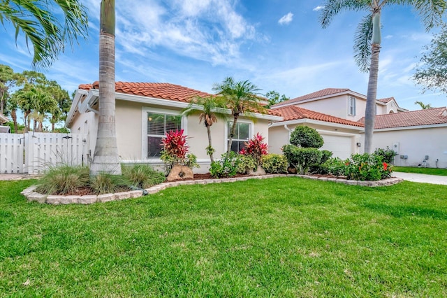 mediterranean / spanish home with fence, an attached garage, stucco siding, a tile roof, and a front yard