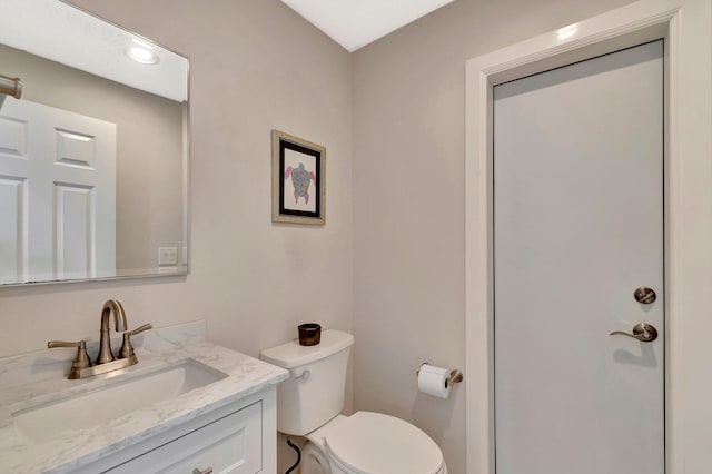 bathroom with vanity, toilet, and recessed lighting