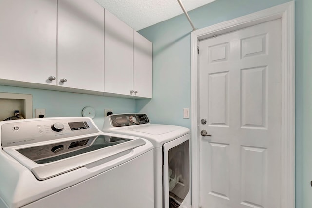 washroom featuring cabinet space and washing machine and clothes dryer