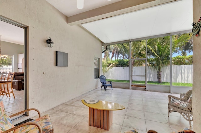 sunroom with tile patterned floors and a notable chandelier