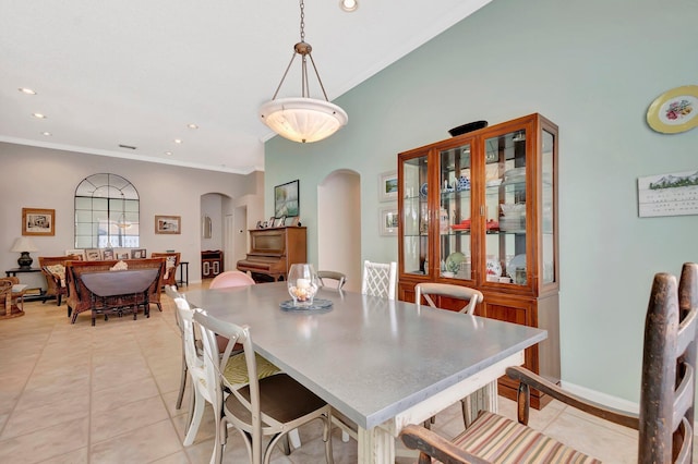 dining area featuring ornamental molding, arched walkways, light tile patterned floors, and recessed lighting