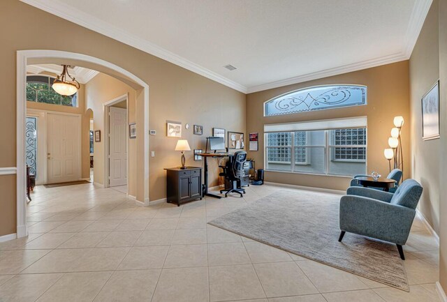 office space with arched walkways, ornamental molding, light tile patterned floors, and baseboards