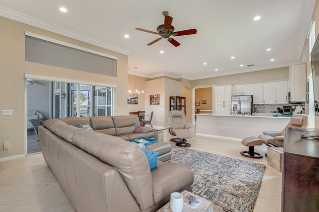 living room with a ceiling fan, light tile patterned floors, recessed lighting, arched walkways, and a chandelier