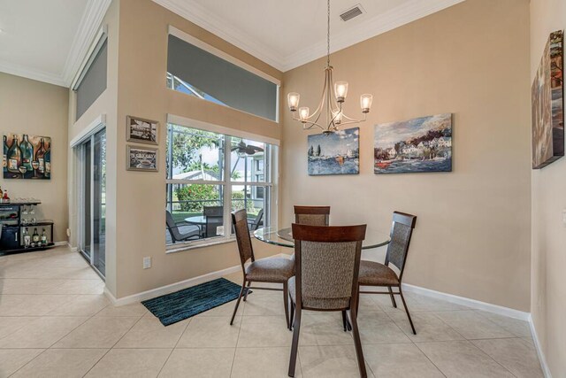 dining space with ornamental molding, light tile patterned flooring, a chandelier, baseboards, and a high ceiling