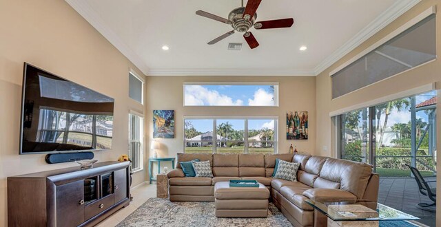 living area with crown molding, a ceiling fan, healthy amount of natural light, a towering ceiling, and recessed lighting