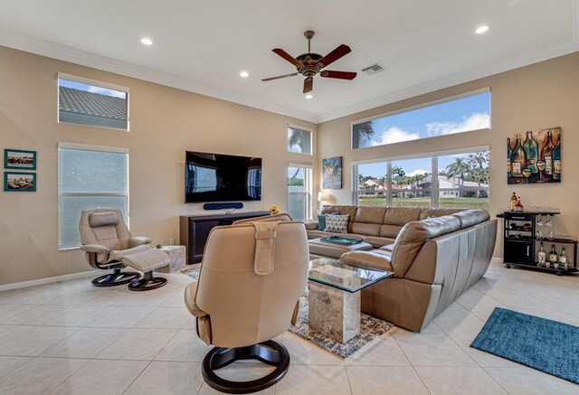 living area with ceiling fan, recessed lighting, ornamental molding, light tile patterned floors, and baseboards