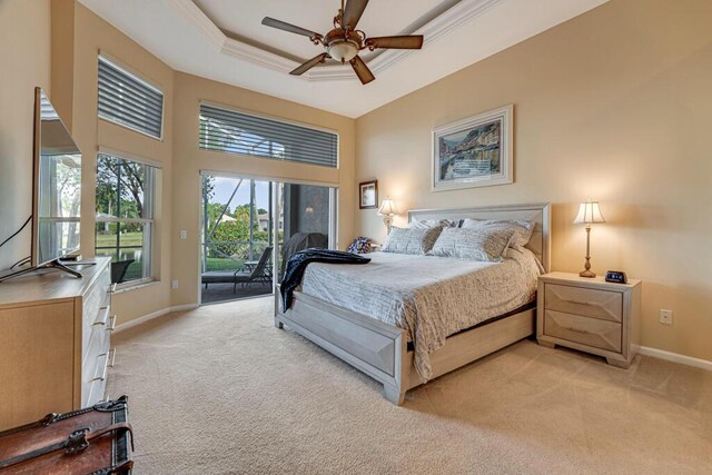 bedroom featuring light carpet, access to exterior, baseboards, a tray ceiling, and ceiling fan