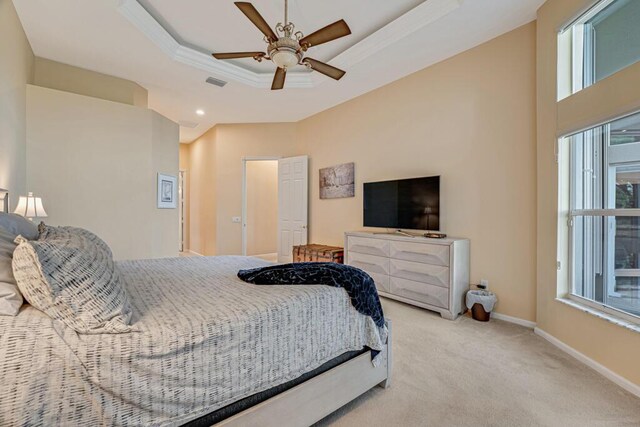 bedroom with a raised ceiling, ornamental molding, carpet floors, baseboards, and ceiling fan