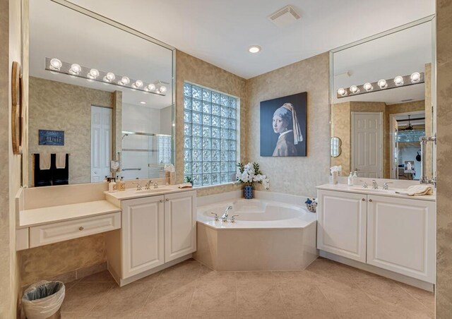 bathroom featuring tile patterned flooring, a stall shower, a garden tub, two vanities, and wallpapered walls