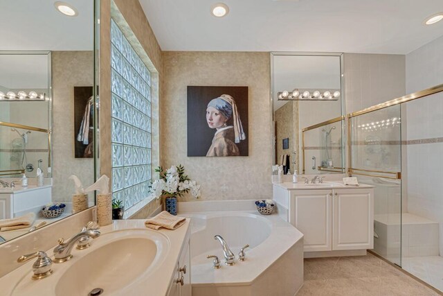 full bath featuring a stall shower, a garden tub, tile patterned floors, recessed lighting, and two vanities