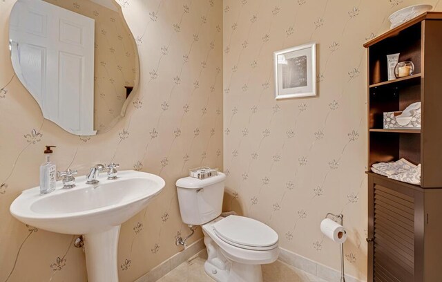 half bathroom with toilet and baseboards