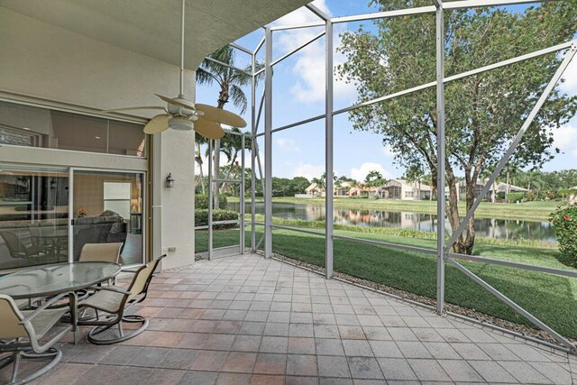 sunroom featuring a water view, a ceiling fan, and healthy amount of natural light