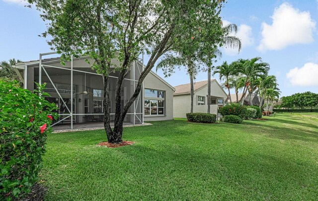 rear view of property featuring stucco siding, a lawn, and a patio area