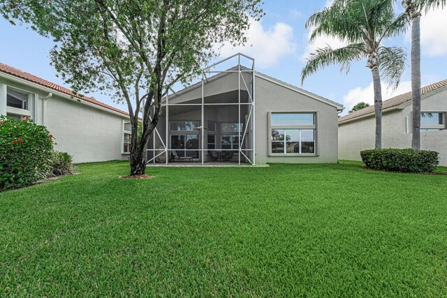 back of house with a yard and stucco siding