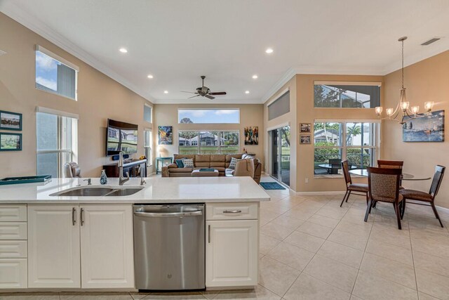 kitchen featuring stainless steel dishwasher, light countertops, light tile patterned floors, ornamental molding, and a chandelier