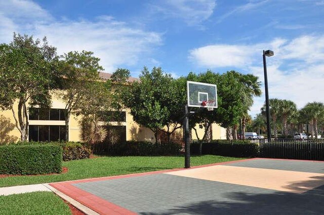 view of basketball court with a yard, fence, and community basketball court