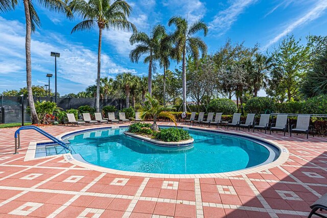 pool with a patio area and fence