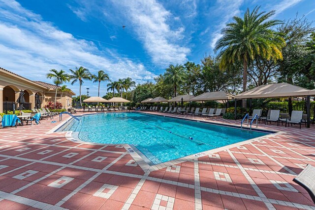 community pool featuring fence and a patio