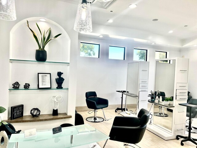 interior space with recessed lighting, a raised ceiling, and wood finished floors