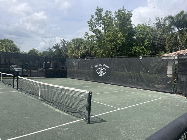 view of tennis court with fence and community basketball court