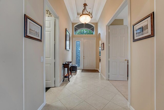 entryway featuring ornamental molding, light tile patterned flooring, and baseboards