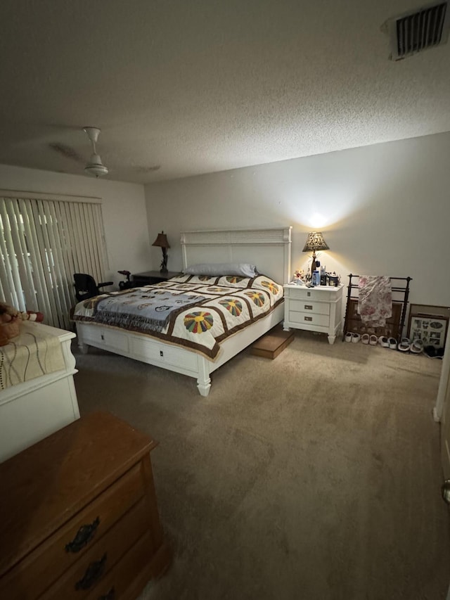 carpeted bedroom with a ceiling fan and visible vents