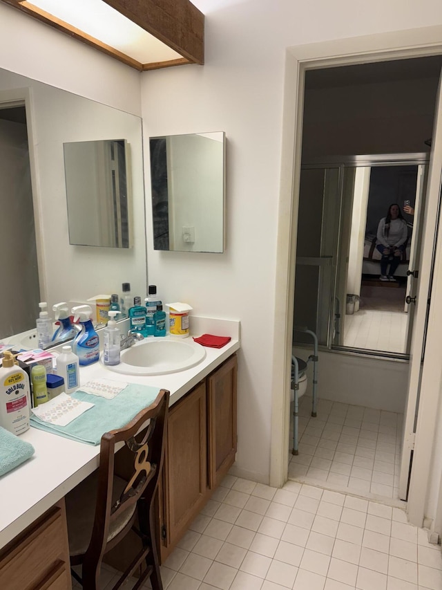 bathroom with tile patterned floors, an enclosed shower, and vanity