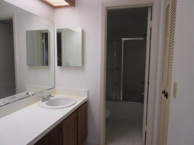 full bath with toilet, vanity, and enclosed tub / shower combo