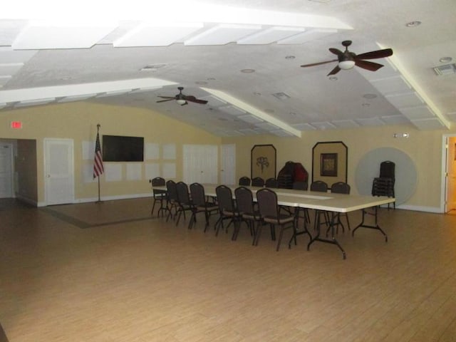 dining area with wood finished floors, visible vents, vaulted ceiling, ceiling fan, and baseboards