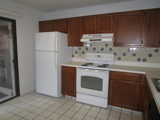 kitchen with under cabinet range hood, white appliances, light countertops, and tasteful backsplash